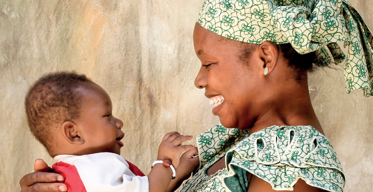 Smiling mother holding toddler