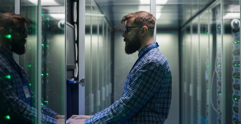 Man standing at computer & typing