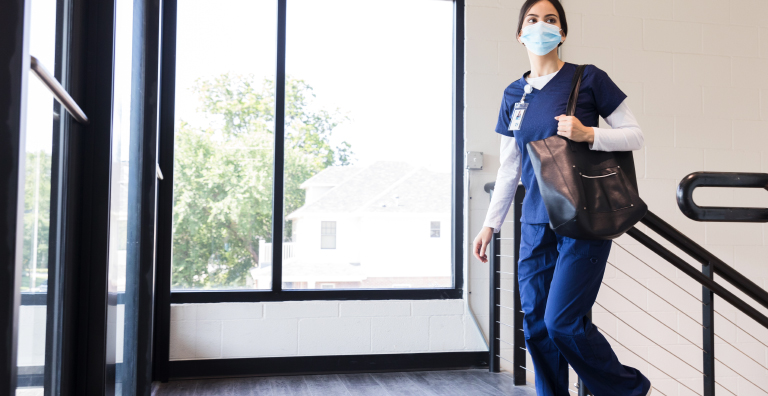 Healthcare employee walking up a flight of stairs