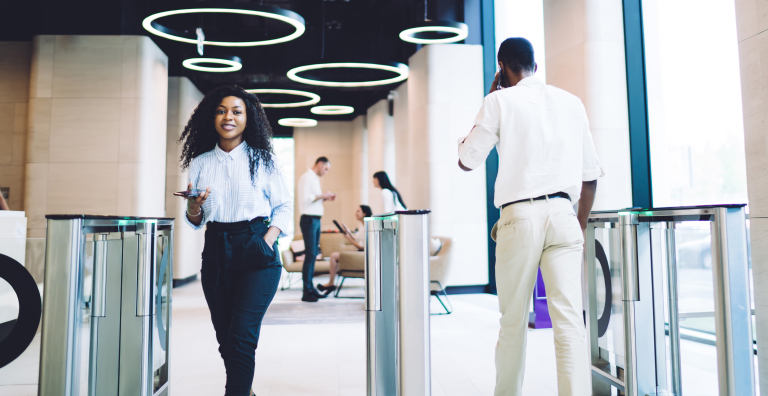 People walking through security gate in office building