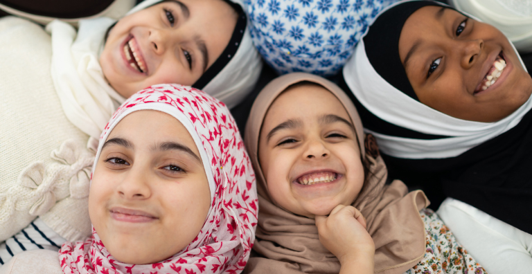 Four women and girls of all ages are smiling and laughing.