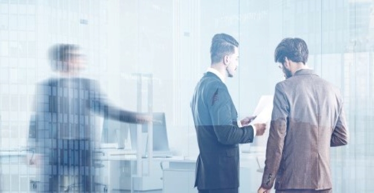 Three employees having conversation in an office.