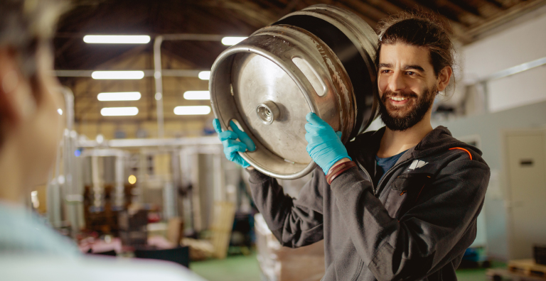 person carrying keg on shoulder