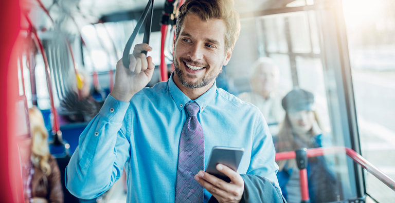 person standing on bus holding phone