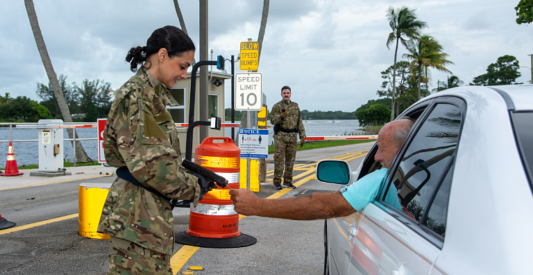 military person scanning ID of person in car