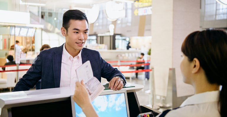 Person getting their passport verified at check-in counter