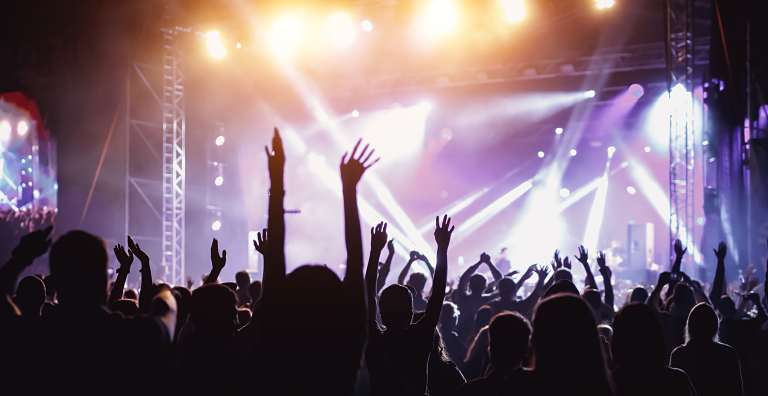 A large crowd dancing and jumping at a concert.